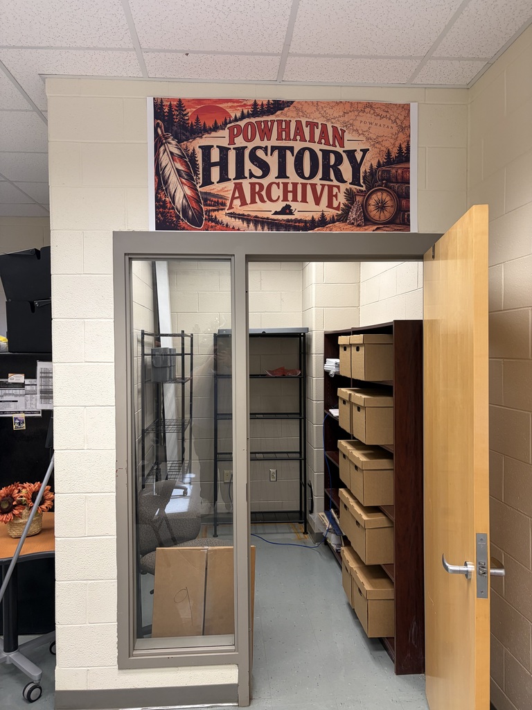 Storage room with archival boxes on shelves. A sign above the door reads Powhatan History Archive.