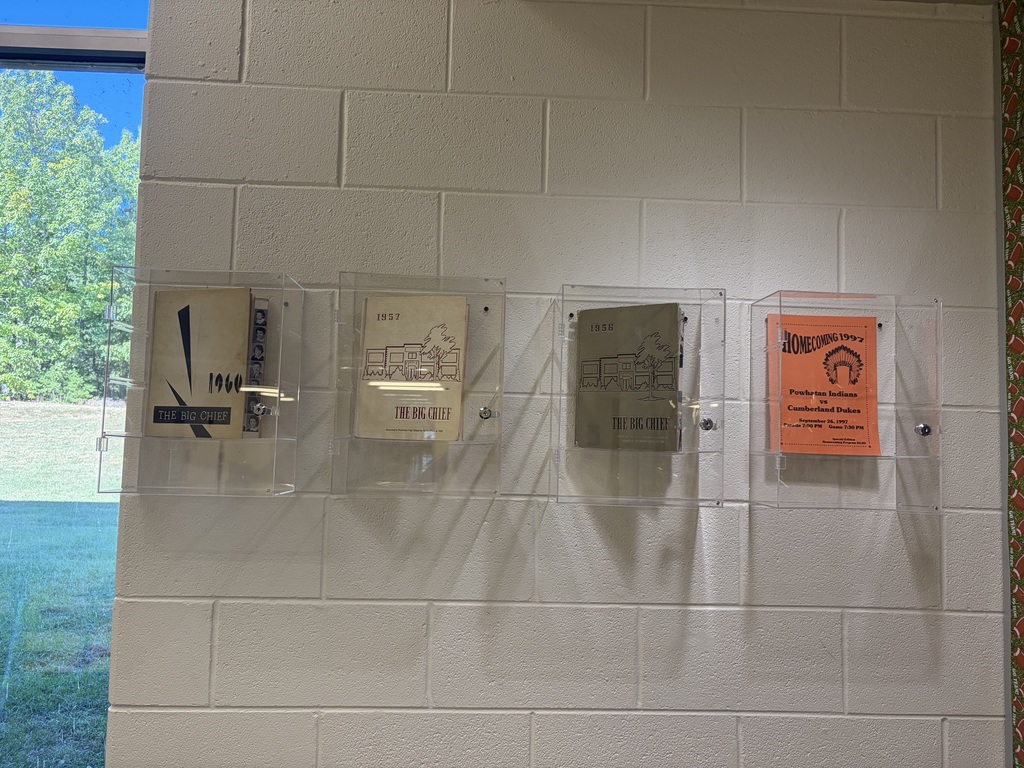 Four individual display cases in a high school hallway show local historical artifacts.