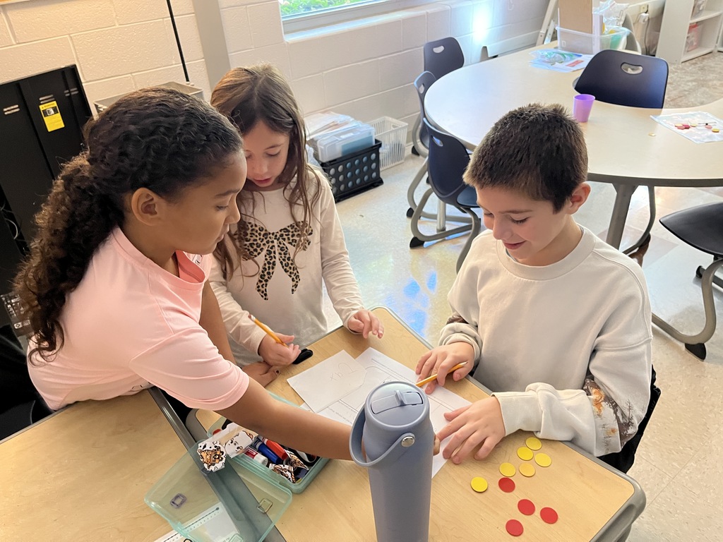 Students work together on an assignment using 10 pieces of candy split into different combinations to explore equality and inequality.