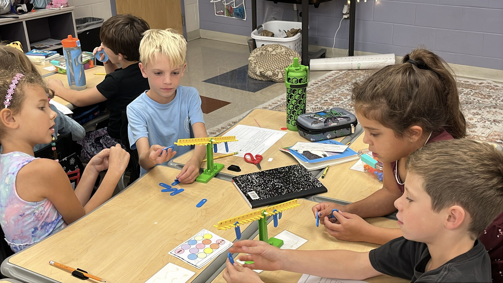 Groups of students  work with a balance to help them explore equality and inequality.