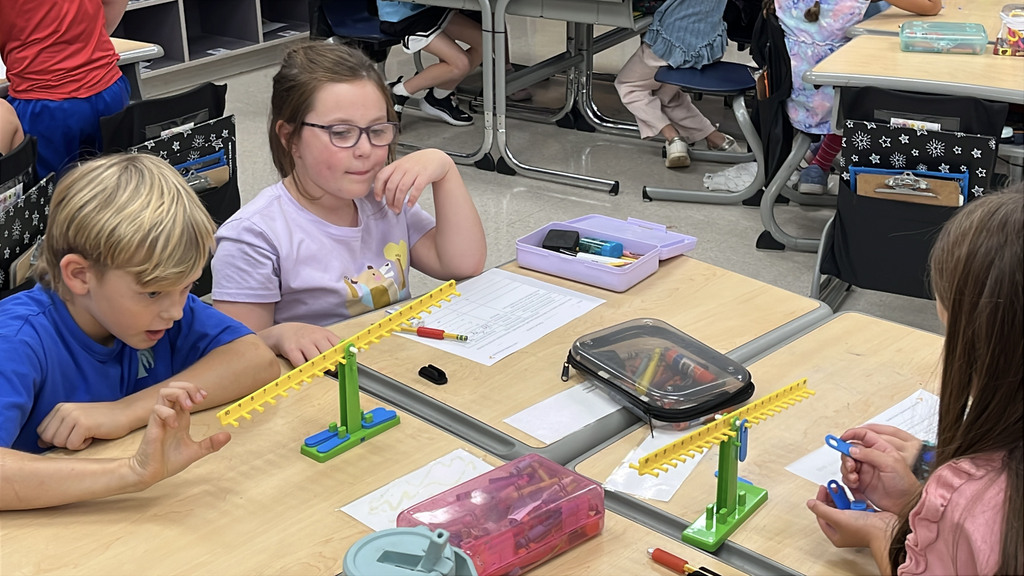 Groups of students  work with a balance to help them explore equality and inequality.