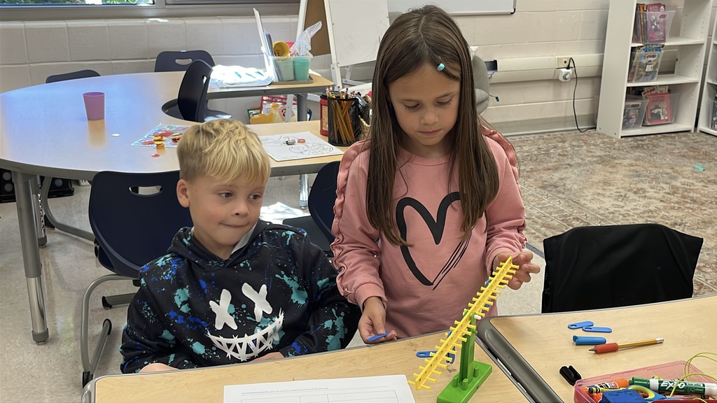 A group of students  works with a balance to help them explore equality and inequality.