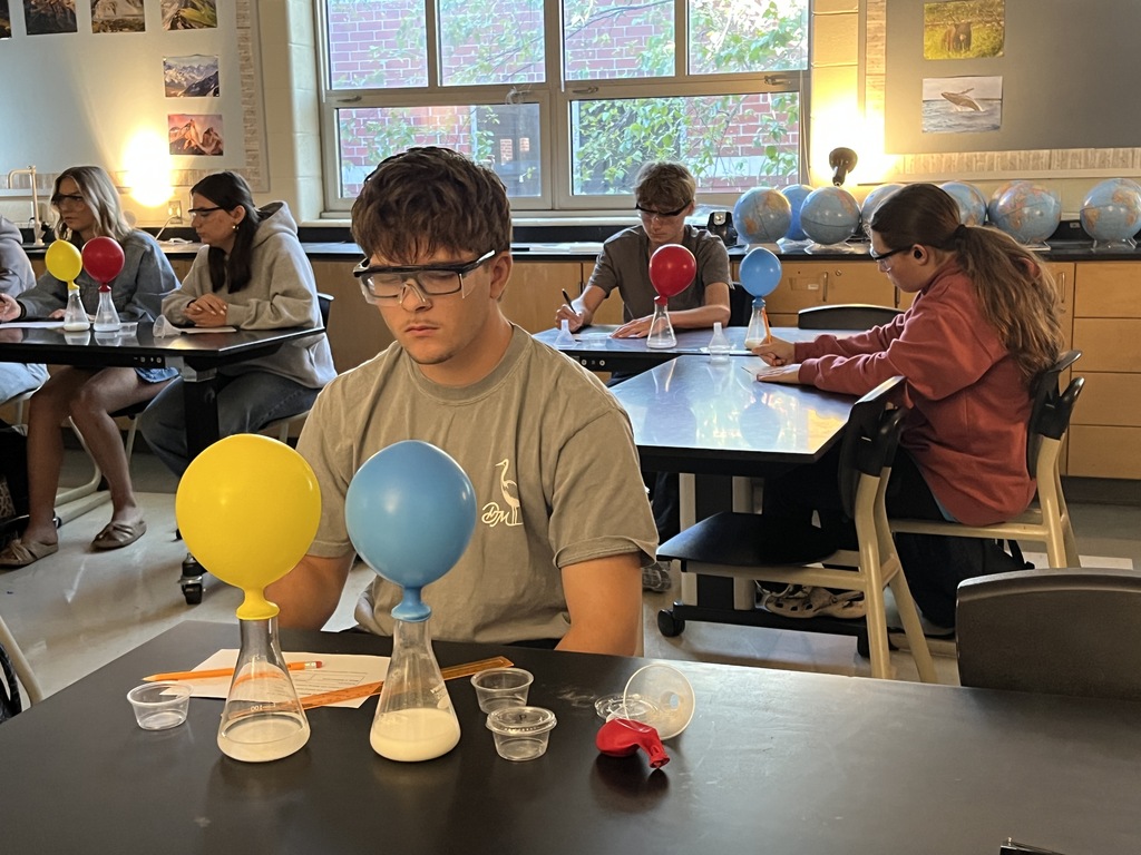 Students conduct an experiment where they combine baking soda and vinegar in a closed system, capture the carbon dioxide gas produced by the reaction in an attached balloon, and measure and record the balloons’ dimensions. 