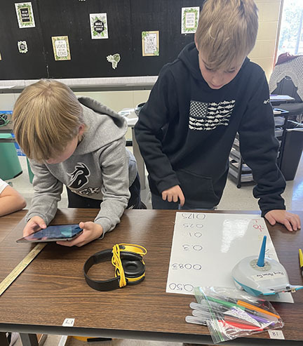Two students use a Finch Robot to review math skills.
