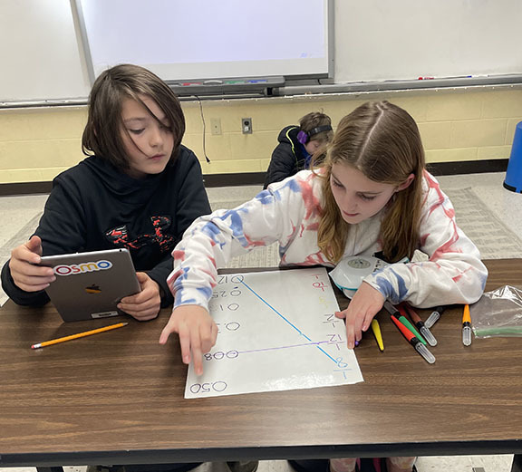 Two students use a Finch Robot to review math skills.