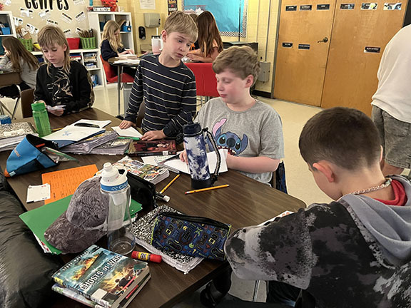  Students fold a paper airplane. 