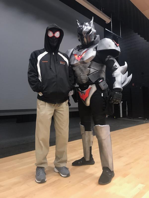 A person in a Spiderman costume and a decked out Batman costume pose for the camera.