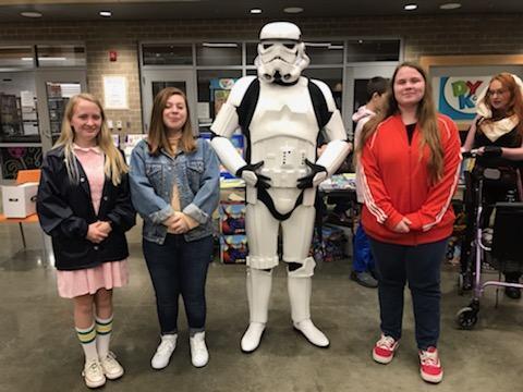 A Storm Trooper and three females pose for a photo.