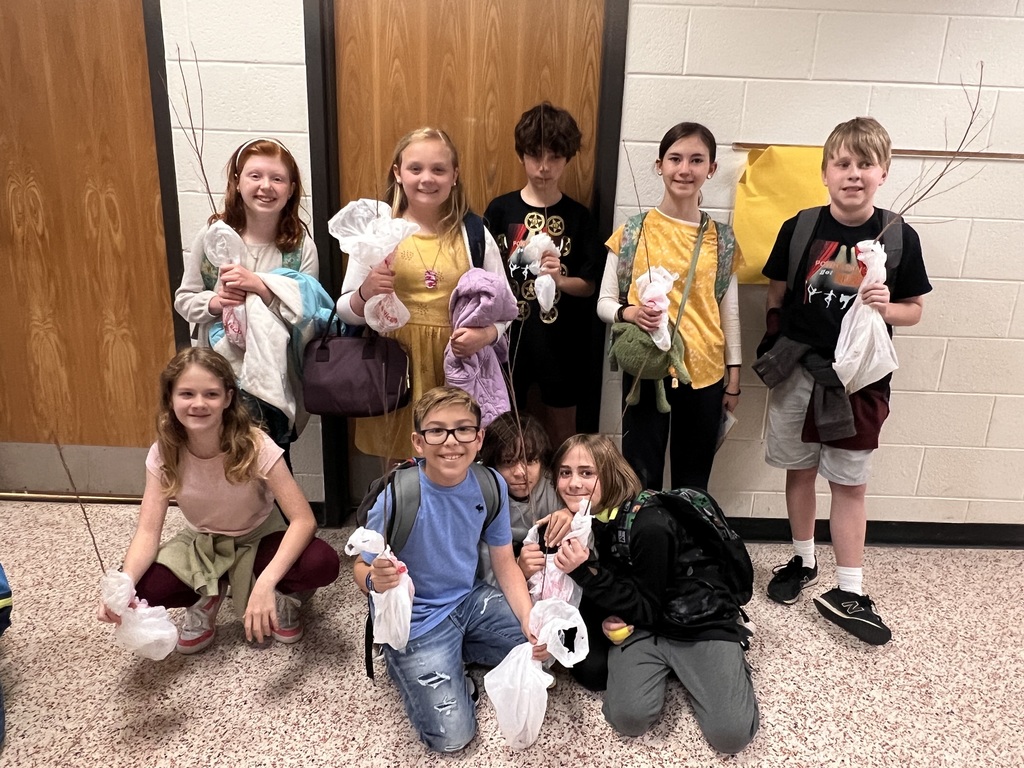 A group of children hold tree seedlings they can take home and plant.