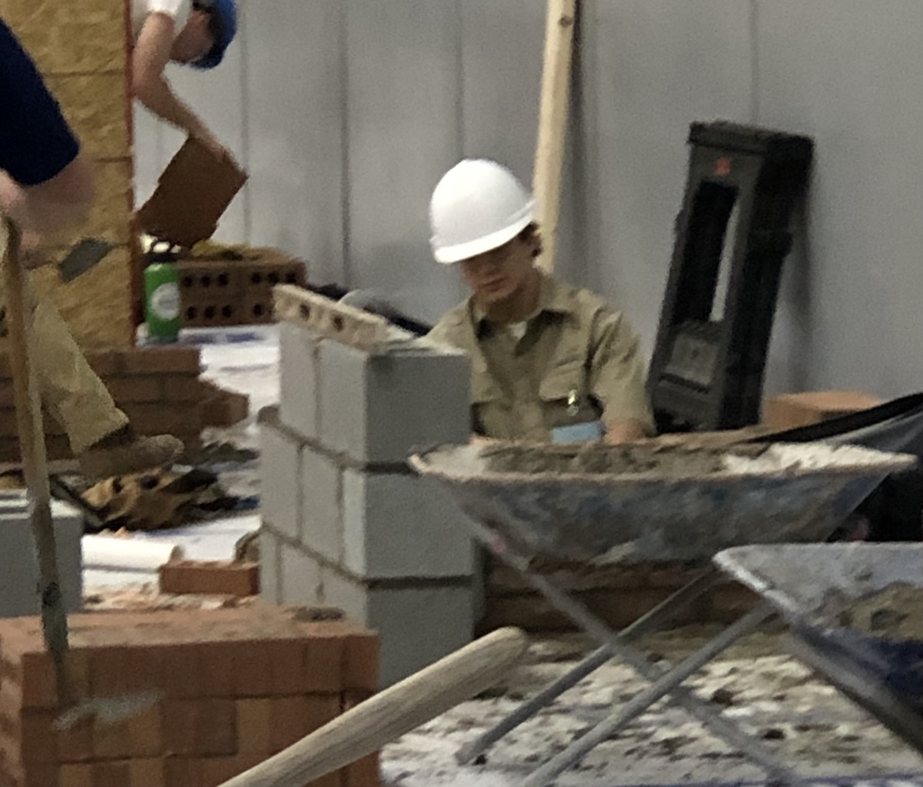 A teen competes in a masonry competition.