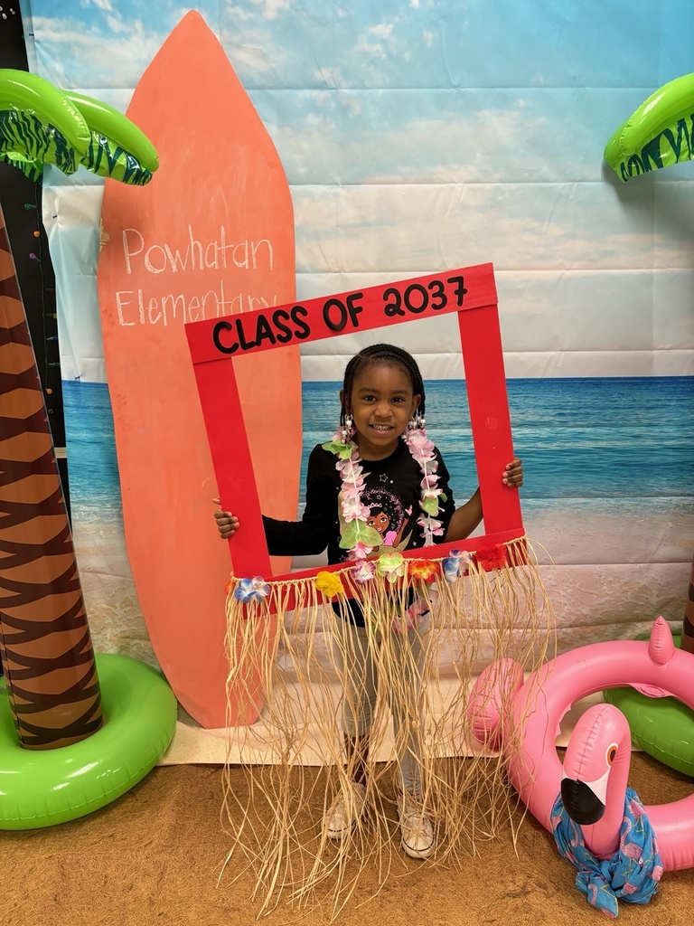 A child poses for a photo in front of a beach-themed backrop.