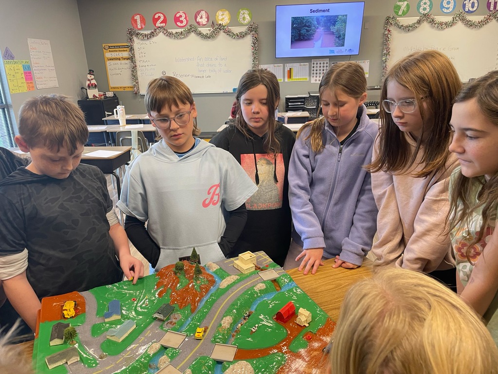 5th grade science students with a diagram about water conservation