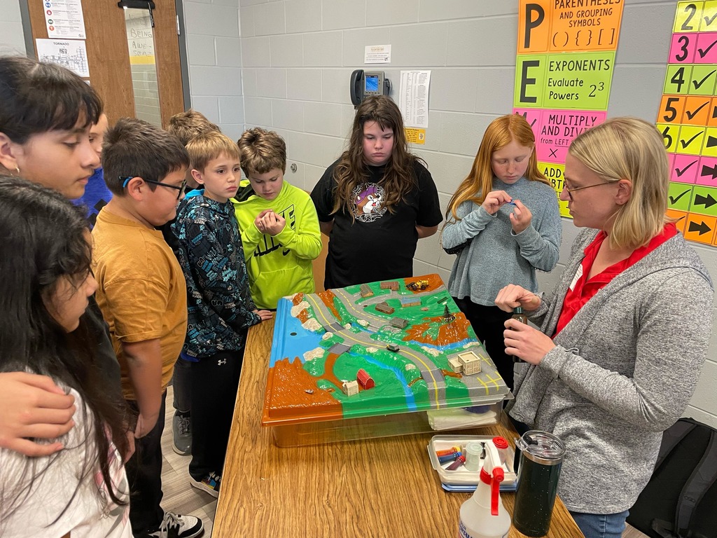 5th grade science students with a diagram about water conservation