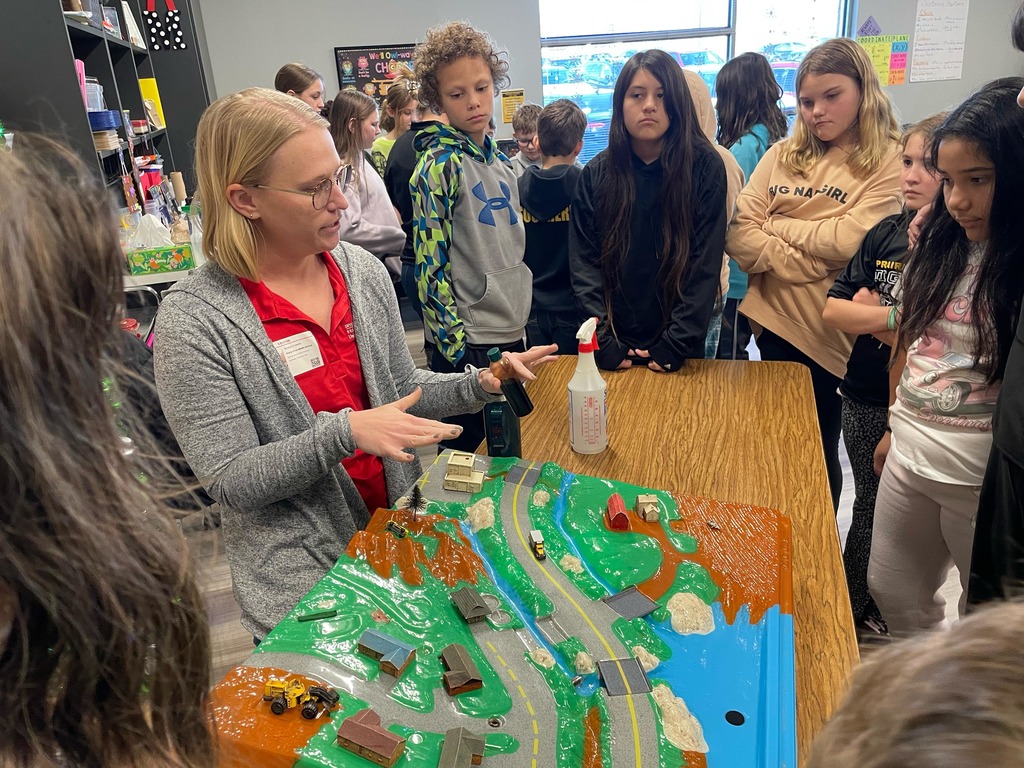 5th grade science students with a diagram about water conservation