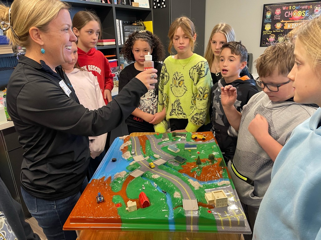 5th grade science students with a diagram about water conservation