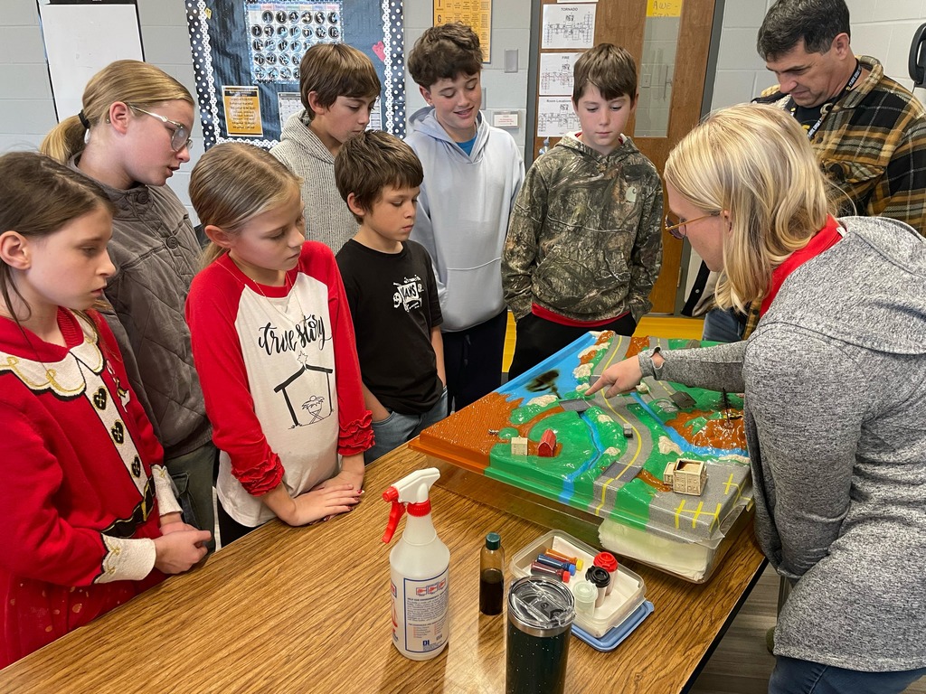 5th grade science students with a diagram about water conservation