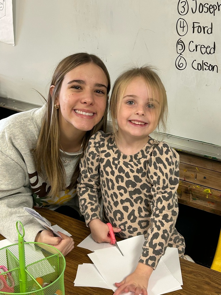 a female high school students smiling with a female preschool student
