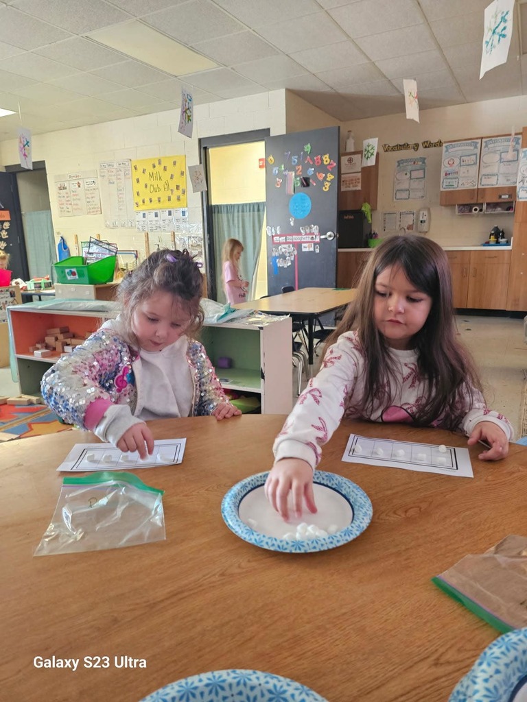 two female students counting out 100 marshmellows