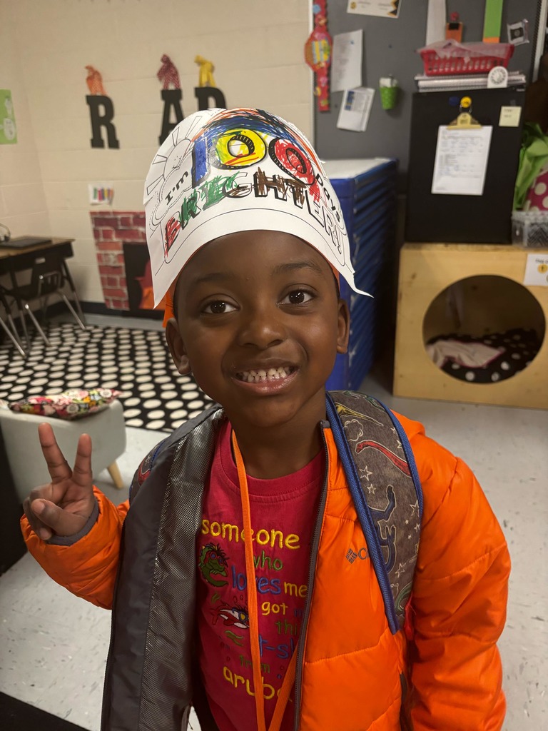preschool student smiling with their paper hat that says I'm 100 days brighter