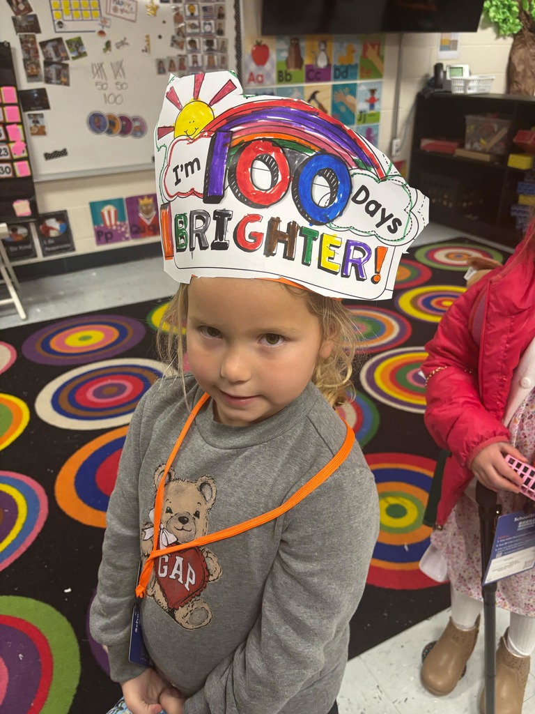 preschool girl smiling with a paper hat that says I'm 100 days brighter 