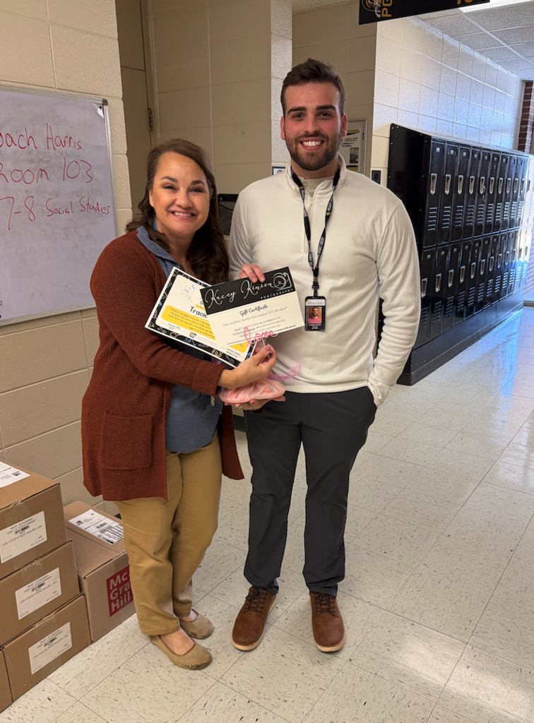 Tracie ashley holding up a certificate for being named the mentor of the month alongside her mentee coach garren wynn