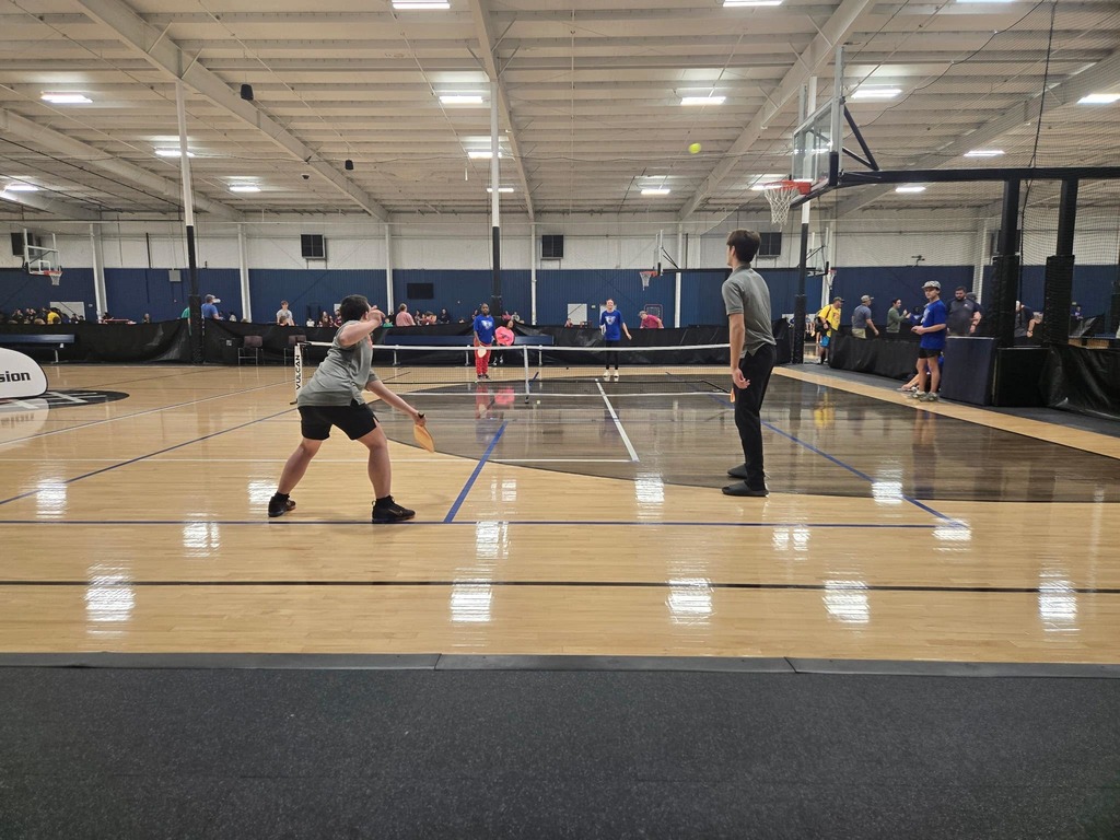 students on an indoor pickleball court actively playing
