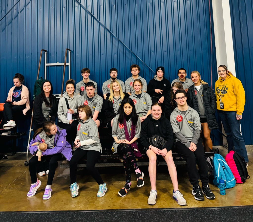 the unified pickleball team sitting together in their grey jerseys smiling