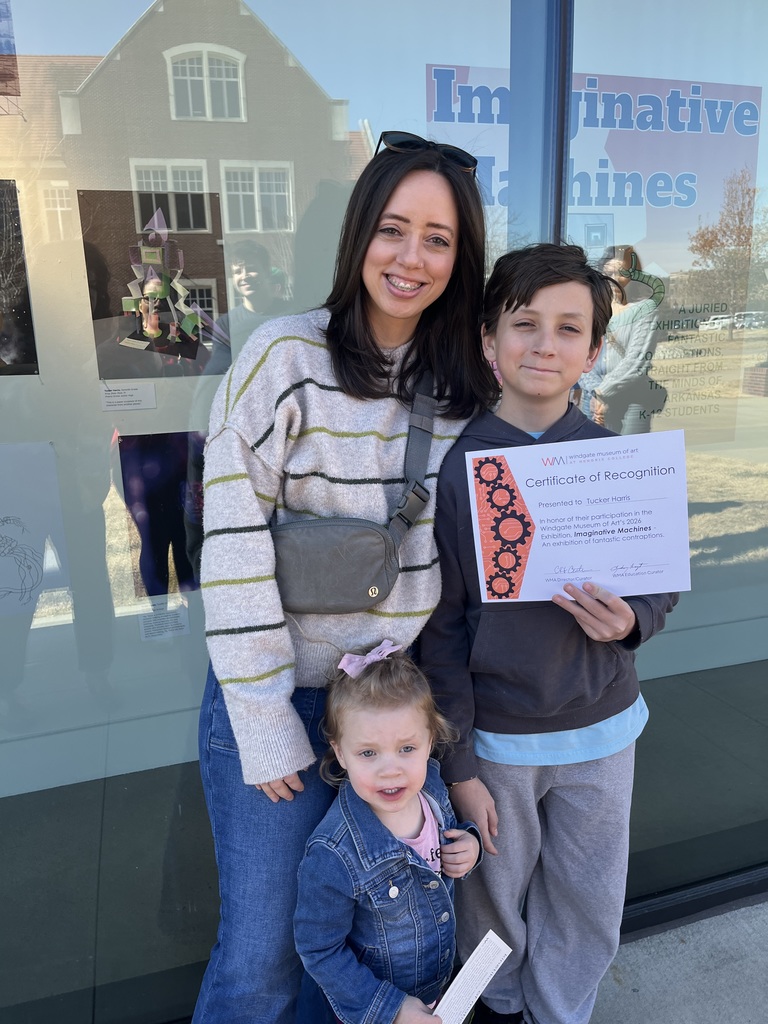 student, Tucker, standing with his mom and sister holding his certificate of recognition