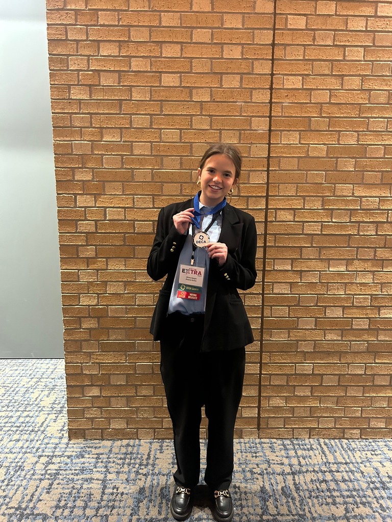 high school girl smiling with her DECA medal