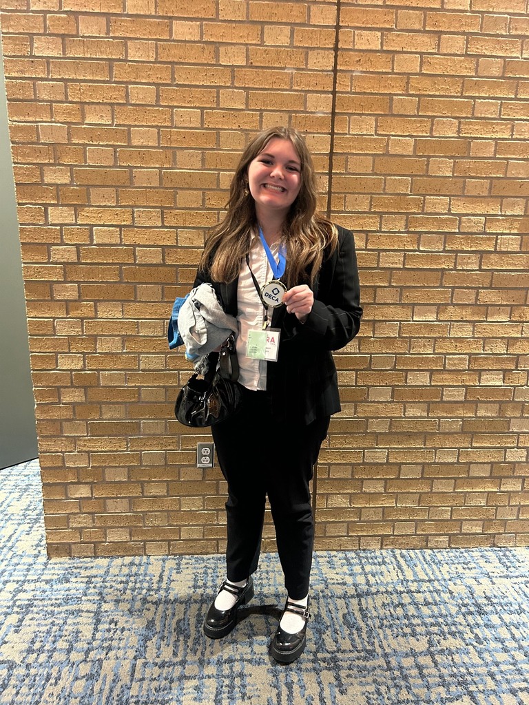 high school girl smiling with her DECA medal
