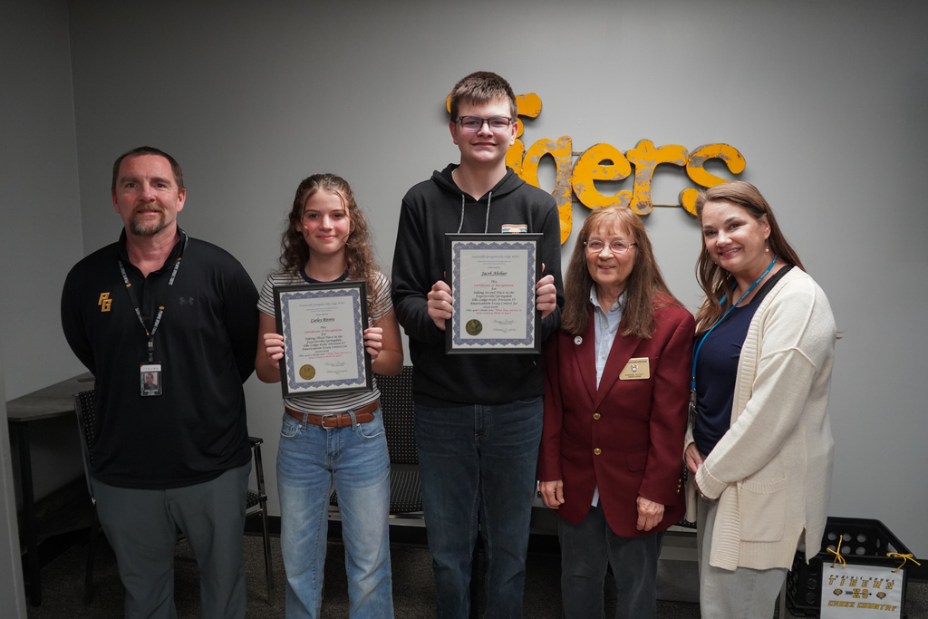 2 eighth graders holding their awards with Elks Lodge representative and their two history teachers