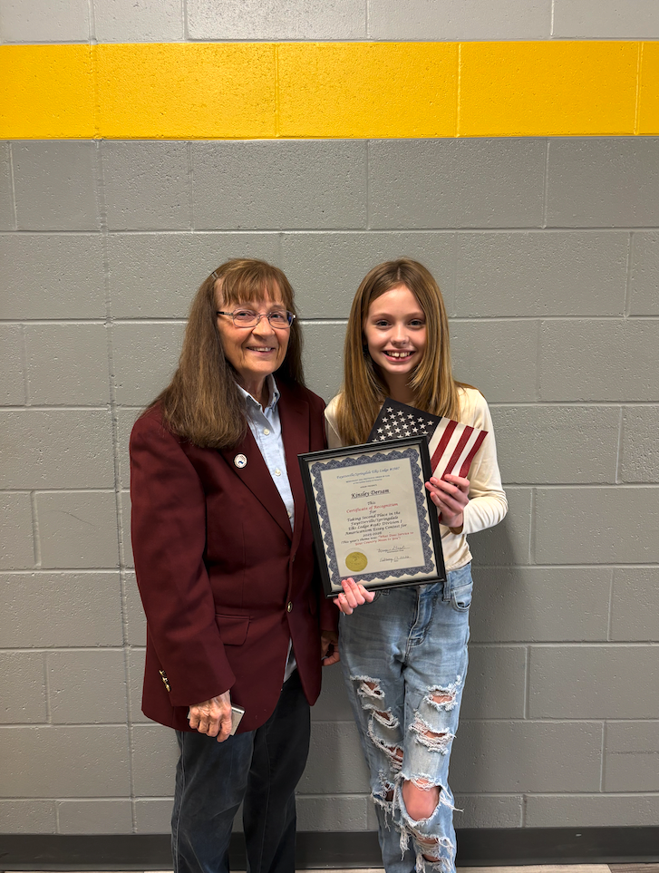 Student, Kinsley, with Elks Lodge representative, holding her award