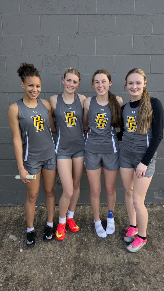 Four girls in their PG Track uniforms smiling together at a meet