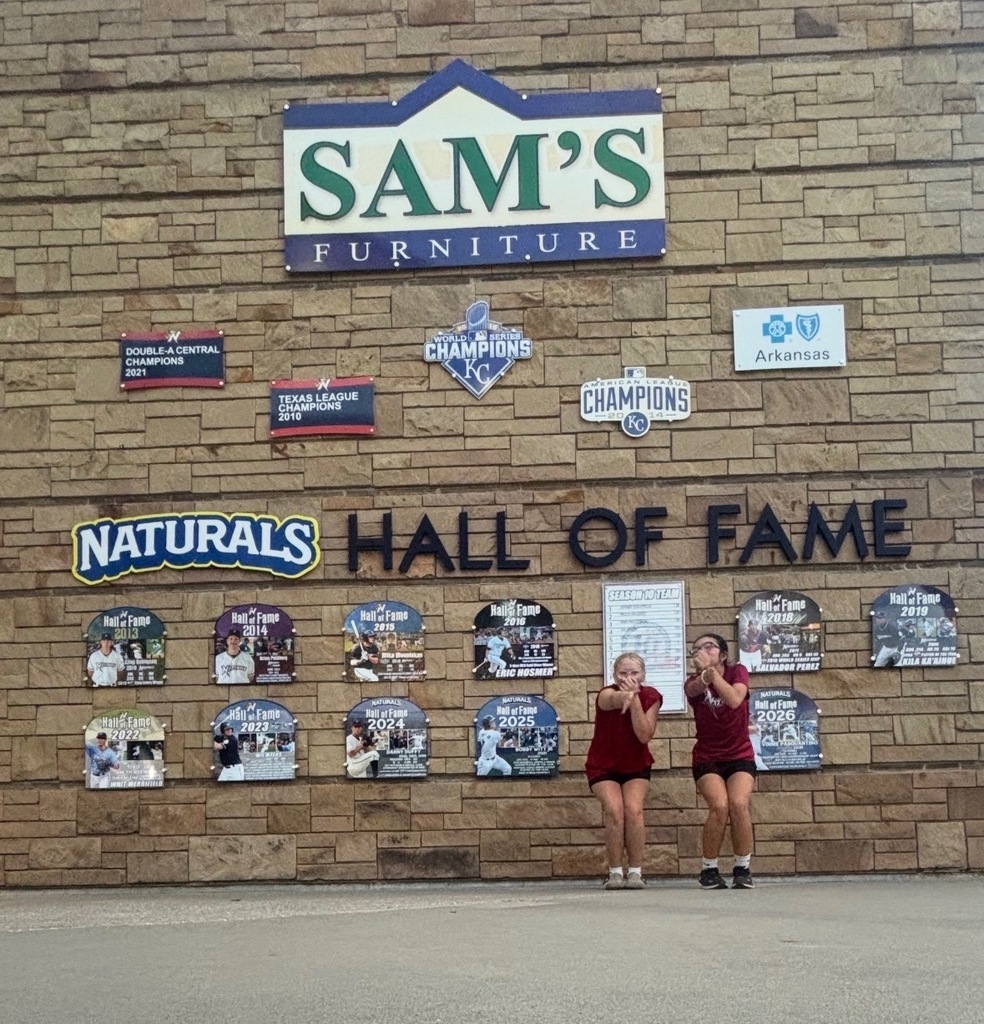 Two students in front of the Hall of Fame wall.