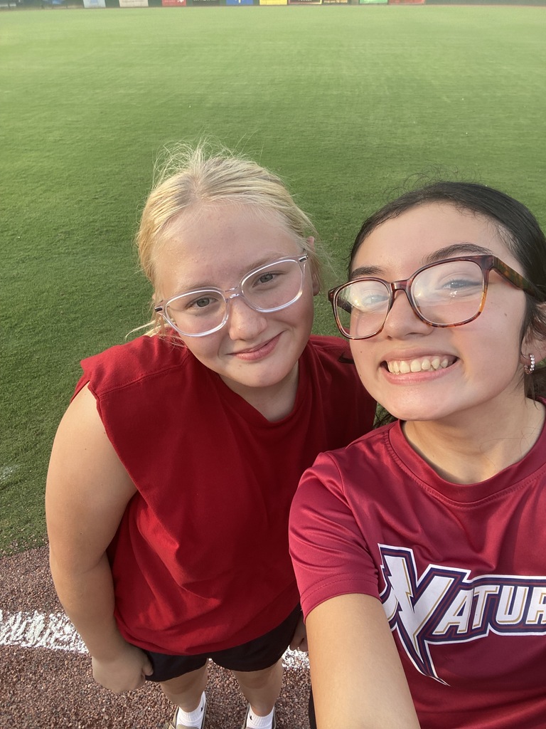 Two students on smile while on the baseball field