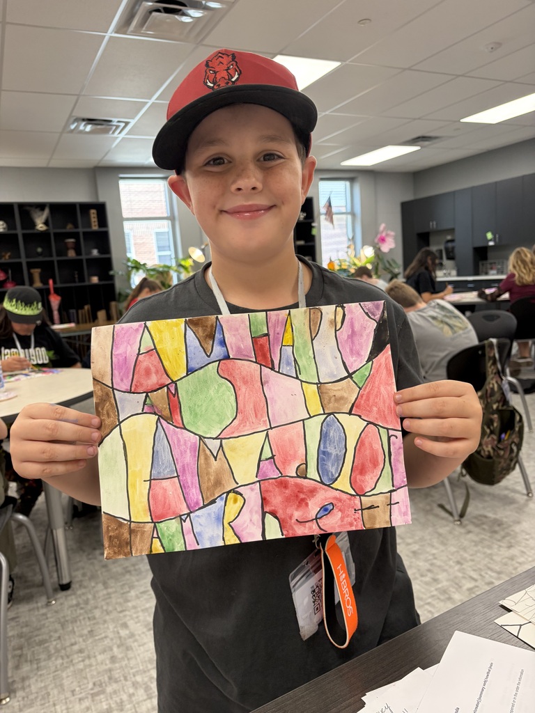 A student in an art class shows his artwork