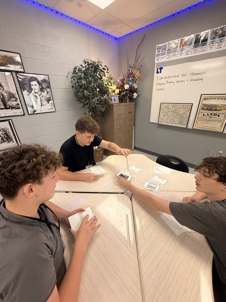 Three students play slapjack as they correctly identify primary and secondary sources