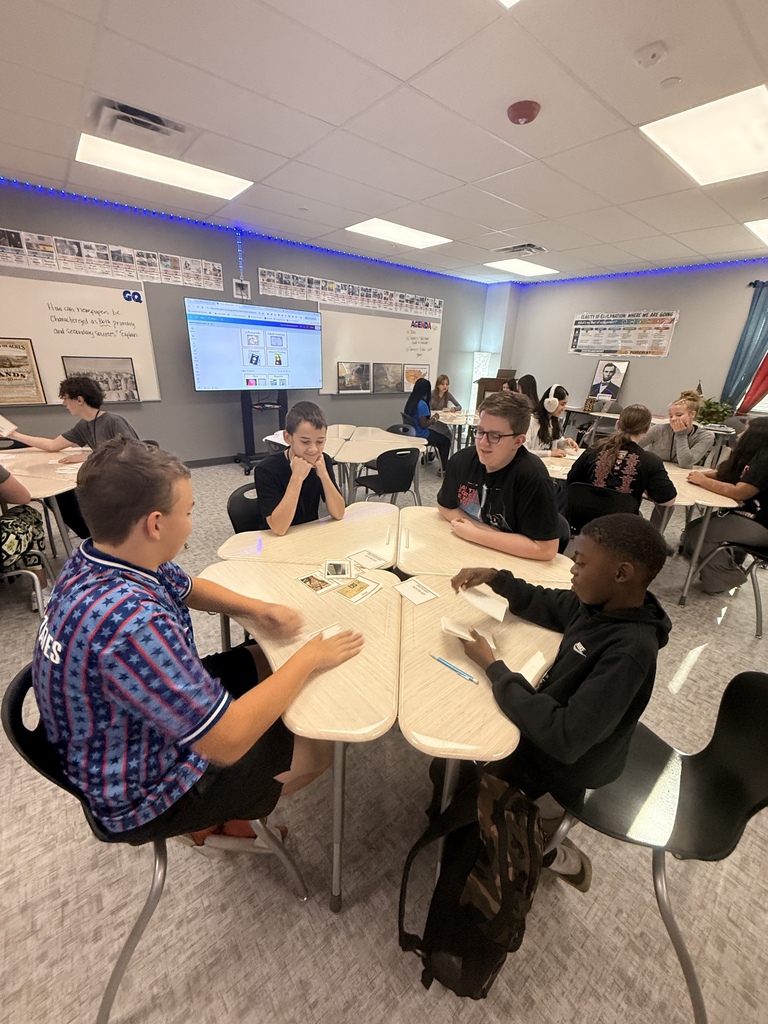 Students sit four to a table and play slapjack as they identify primary and secondary sources