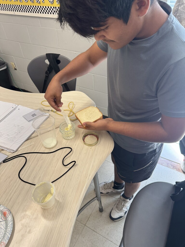 A student spreads butter on bread