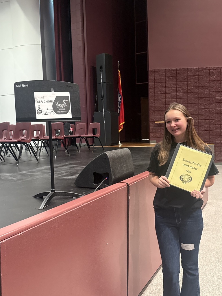 Student holding choir folder.