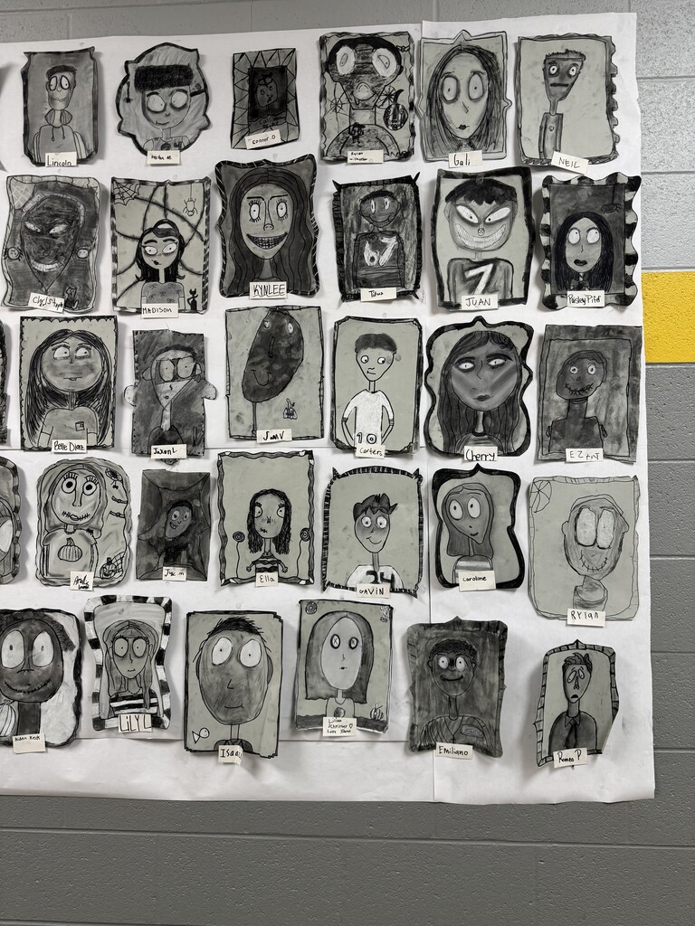 Black and white spooky portraits are displayed together on the wall