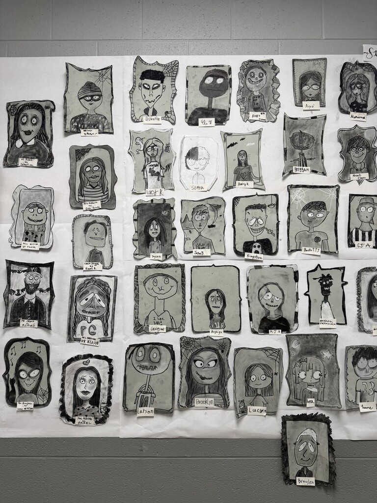 Black and white spooky portraits are displayed together on the wall