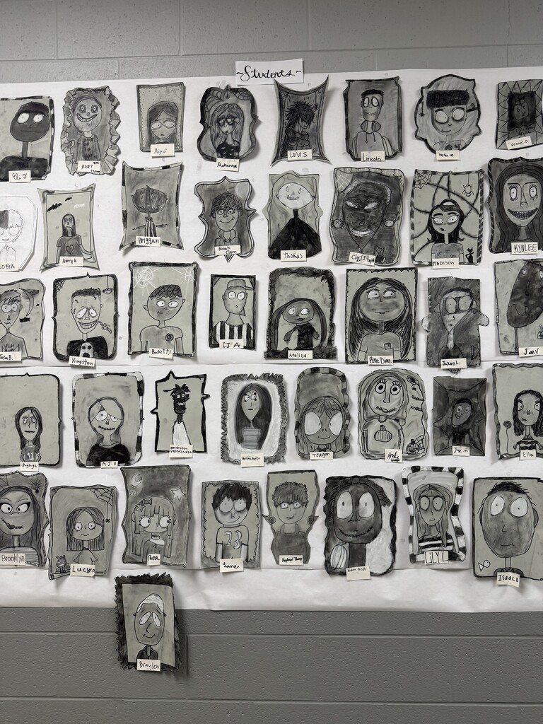Black and white spooky portraits are displayed together on the wall