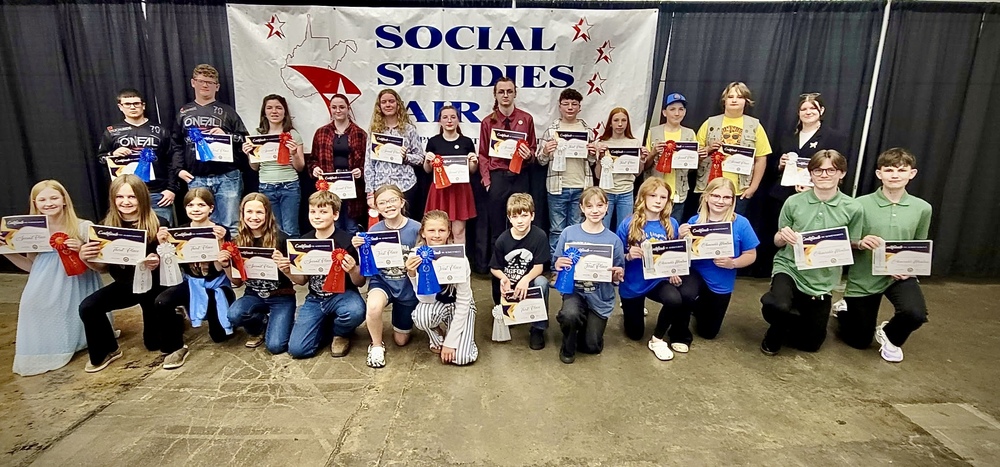 student poses with award