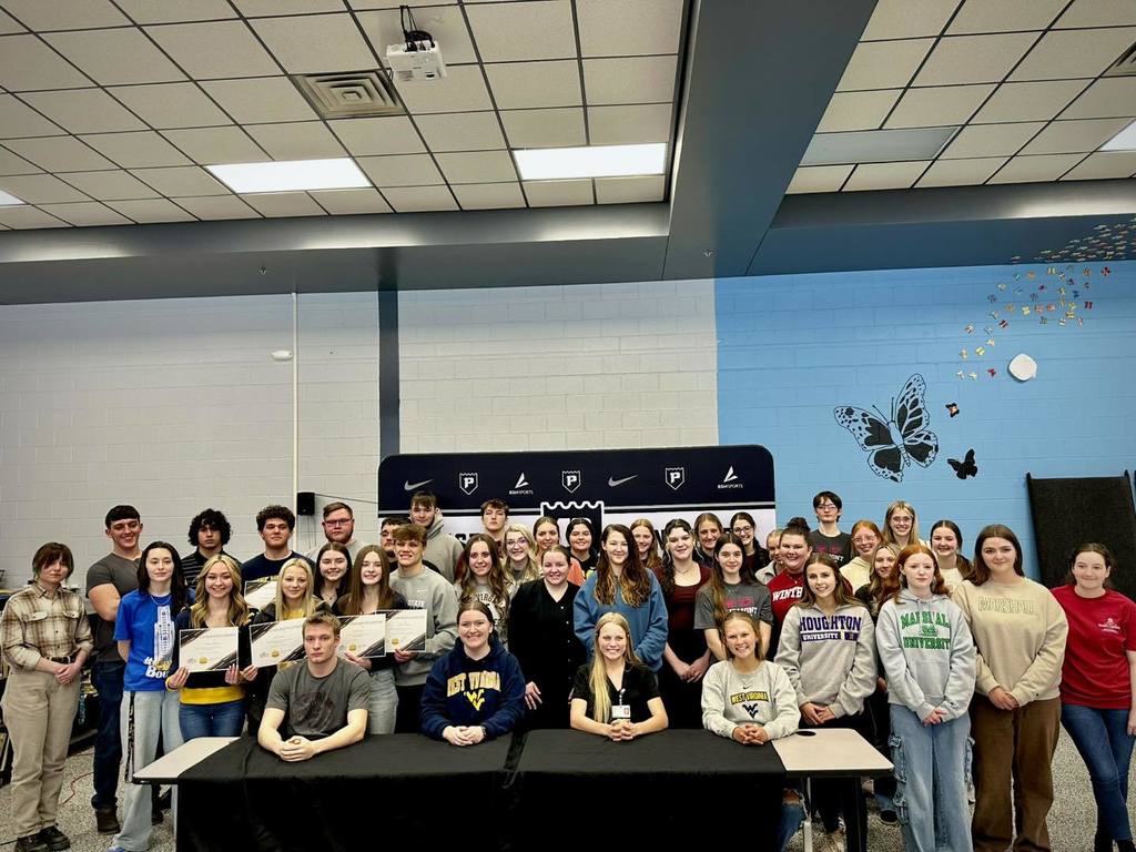 students pose for college signing day
