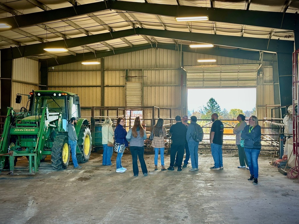 onlookers, men and women take a tour of a farm