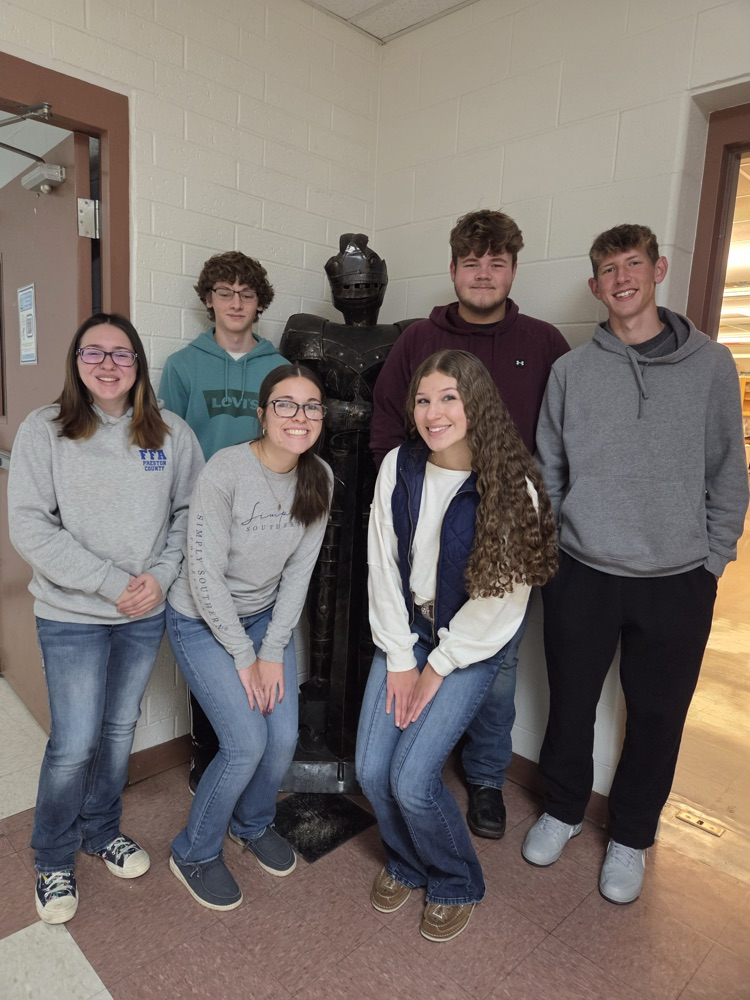 students pose with knight statue