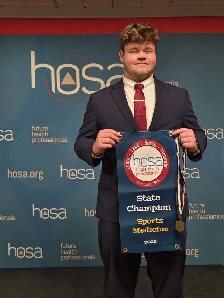 student poses with award