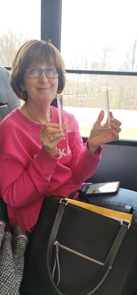 student poses with award