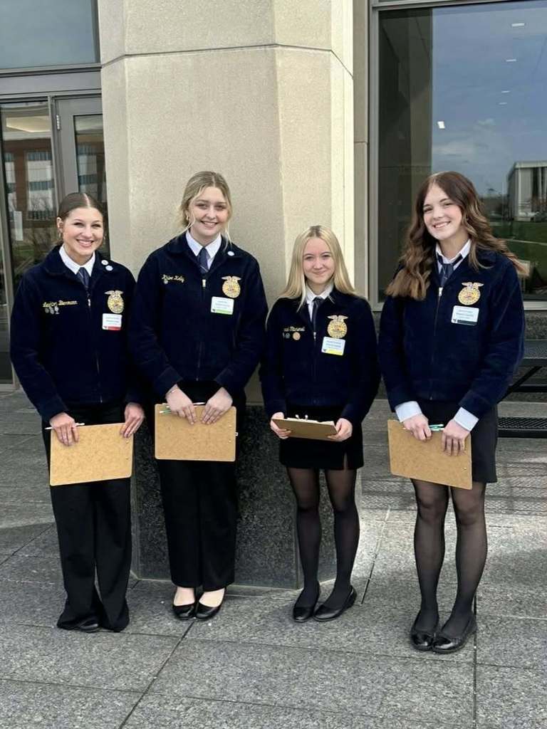 student poses with award